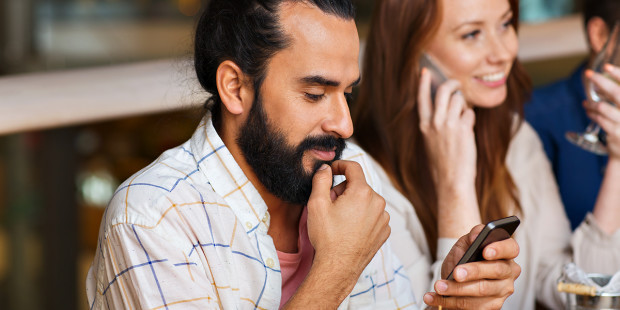 web3-man-on-phone-with-friends-at-restaurant-shutterstock